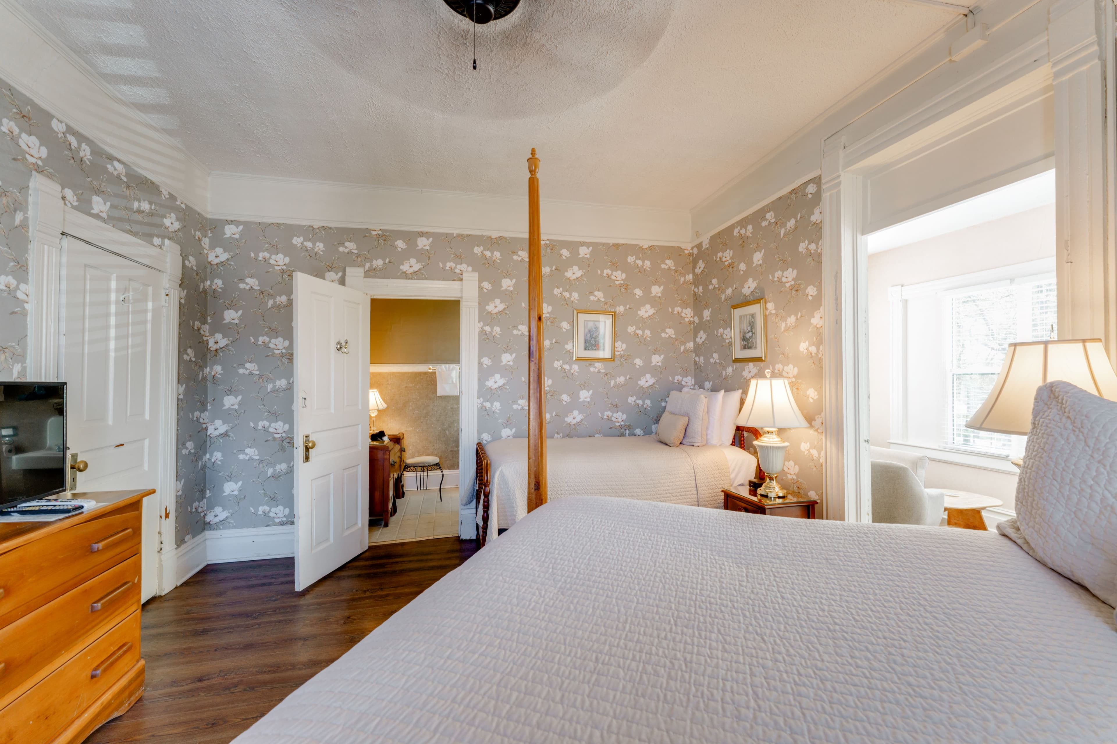 Room Features four posted queen bed, twin bed, and a long dresser with tv on top