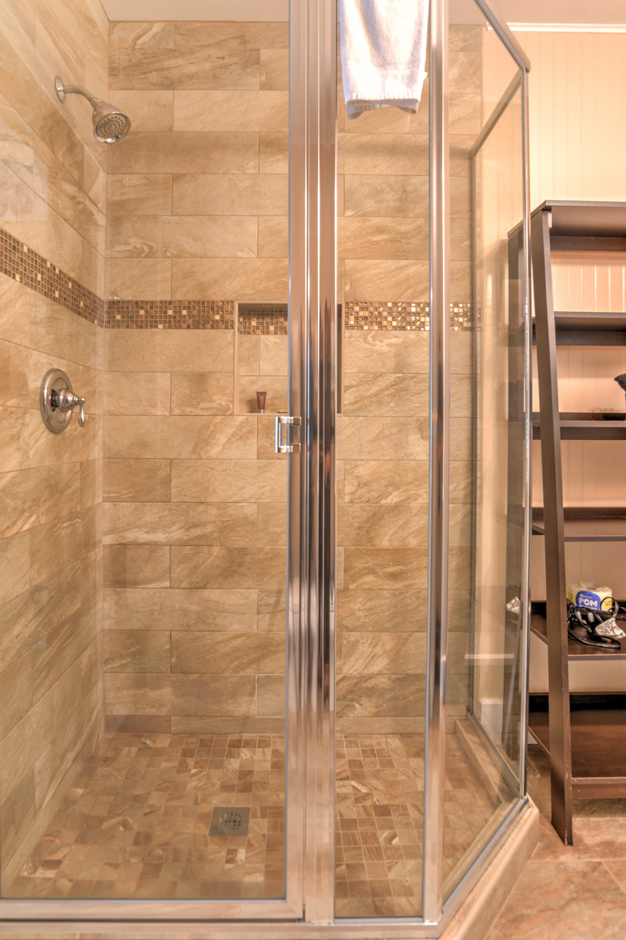 Bathroom featuring a large corner walk-in shower and bathrom shelving unit.