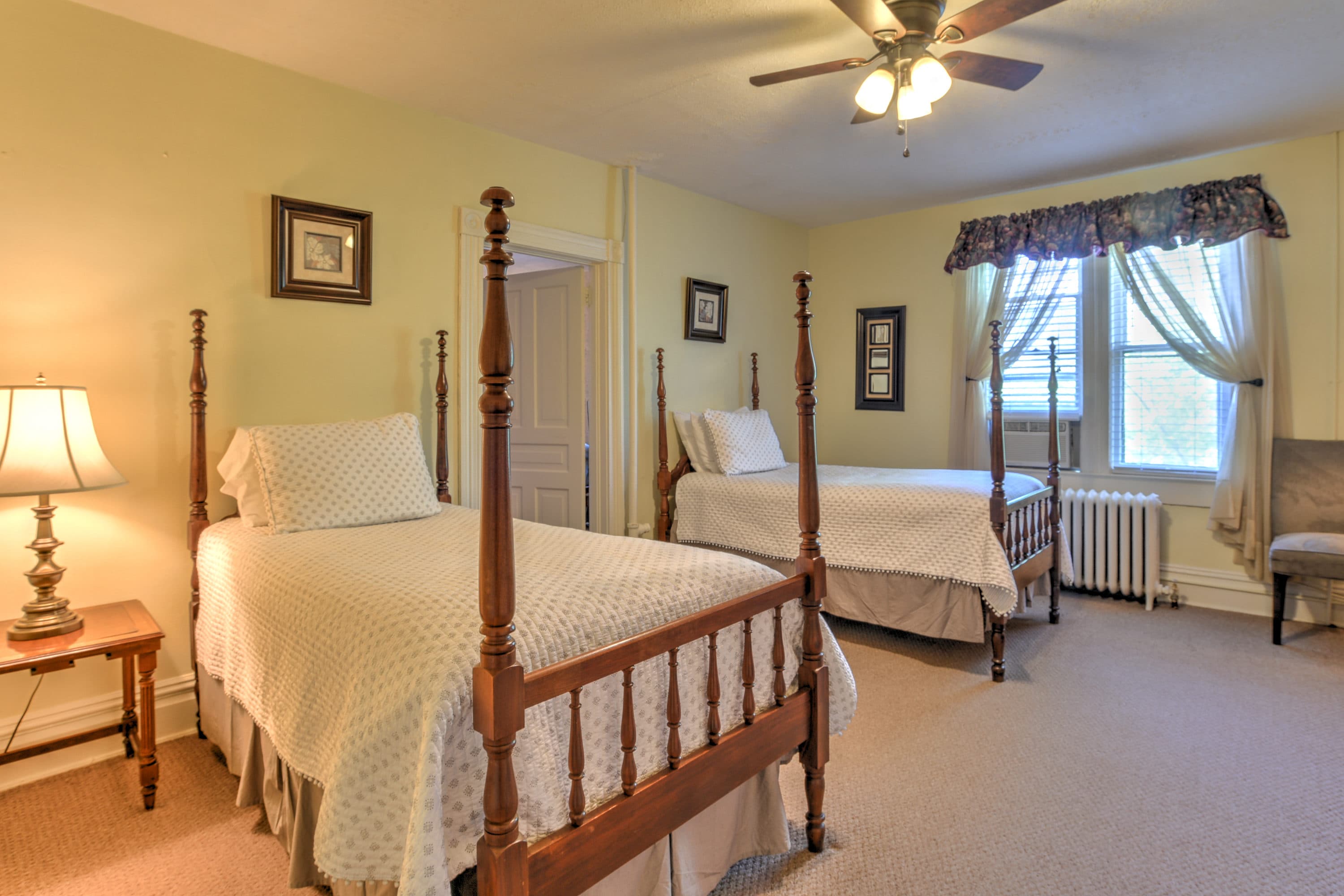 Room features two four posted twin beds.