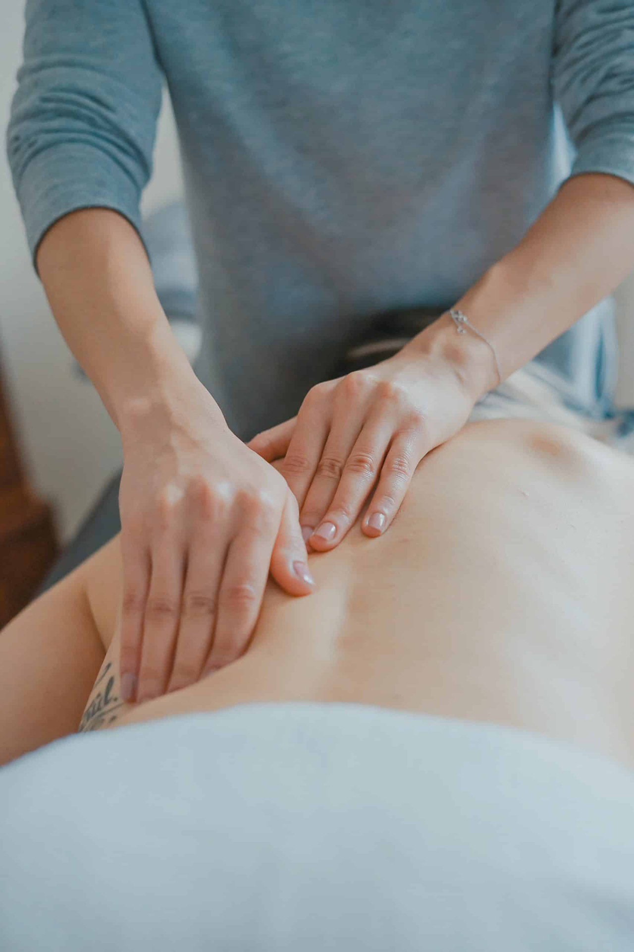 A person receives a massage with hands on their back.