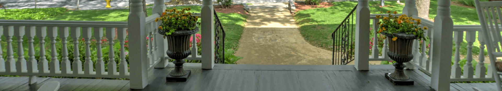 A view from a porch overlooking a landscaped path and garden.
