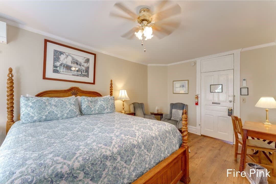 Fire Pink room features a king bed, a desk and chair, and a small seating area with cushioned chairs.