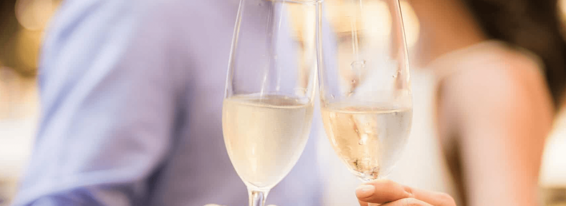 Two glasses of champagne are clinking together in celebration.