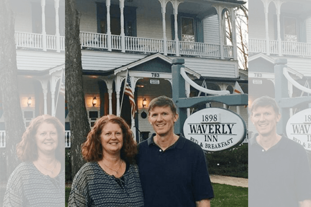 A couple stands smiling in front of the Waverly Inn Bed & Breakfast.