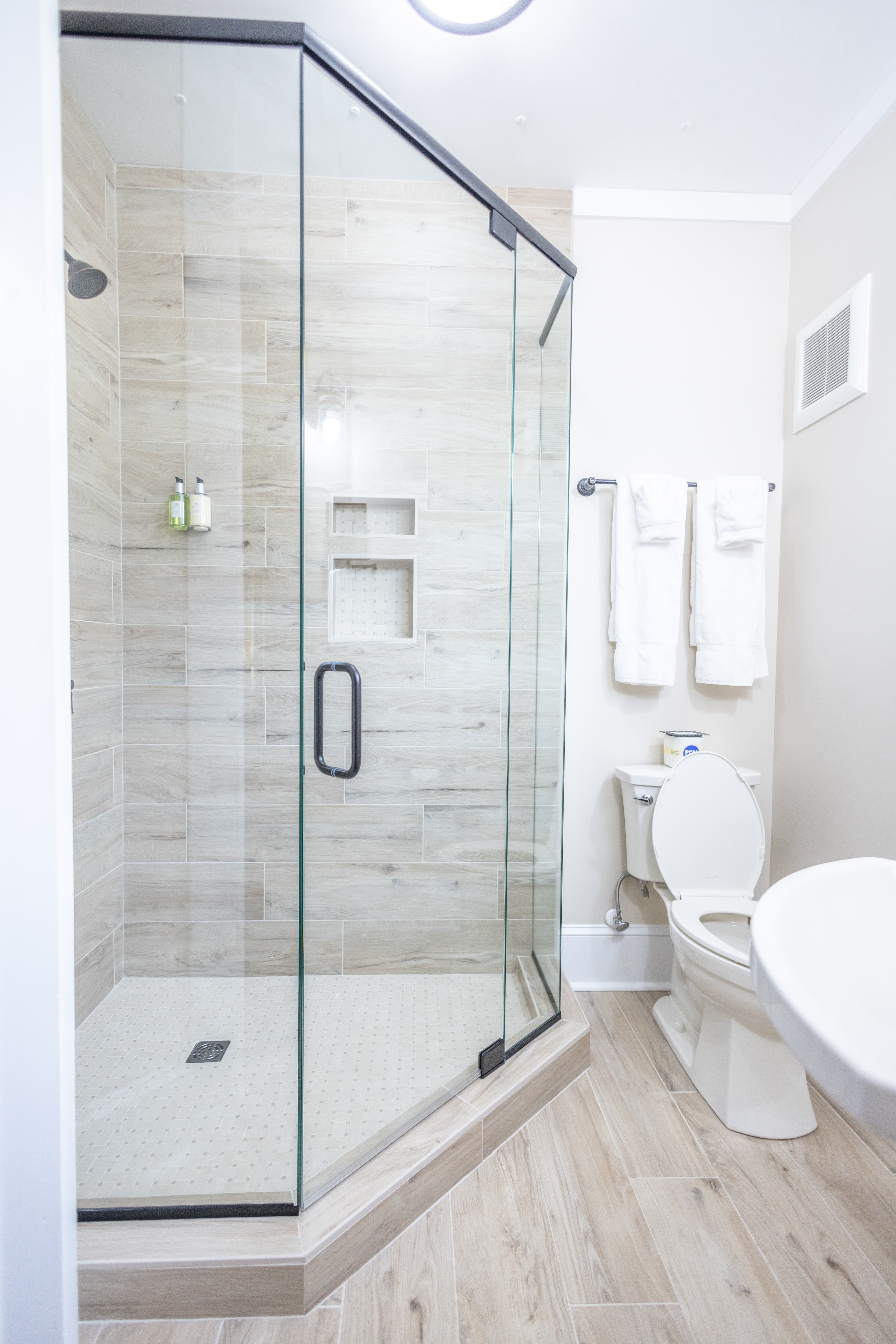 A modern bathroom featuring a glass shower enclosure and a toilet.