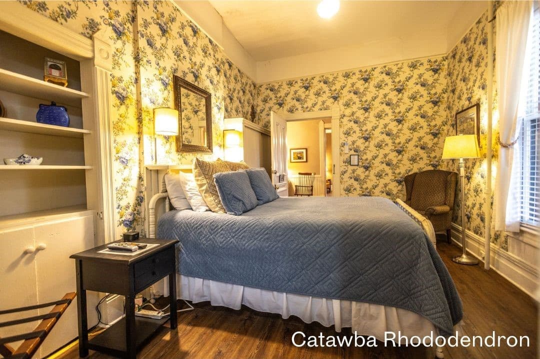 Catawba Rododendron Romm featuring a queen bed, build in book shelf, night stand, and a cushioned chair in the corner.